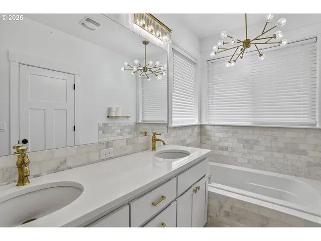 a bathroom with a sink vanity granite tub and a mirror