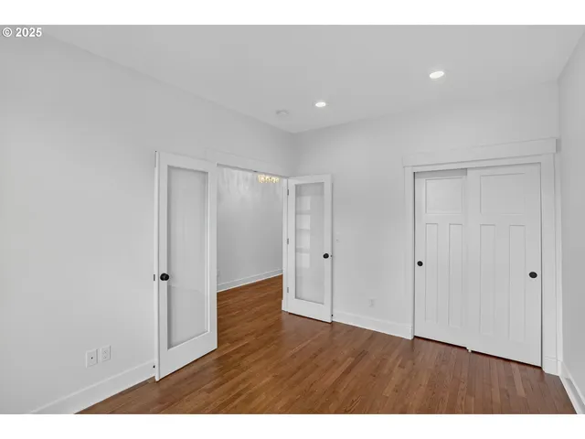 a view of an empty room with wooden floor
