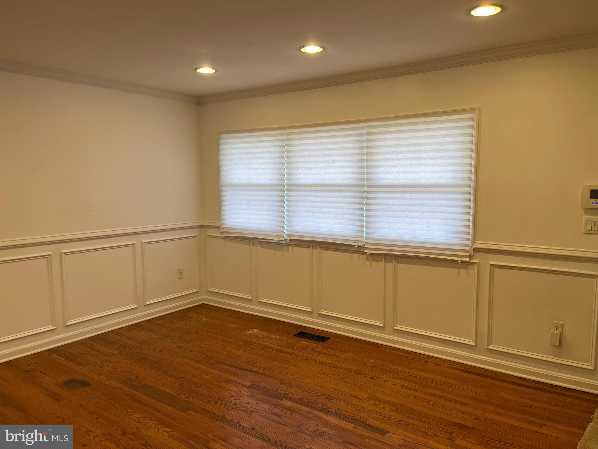8829 Sigrid Road Randallstown, MD 21133 - Photo 3 of 28 a view of an empty room with wooden floor and a window
