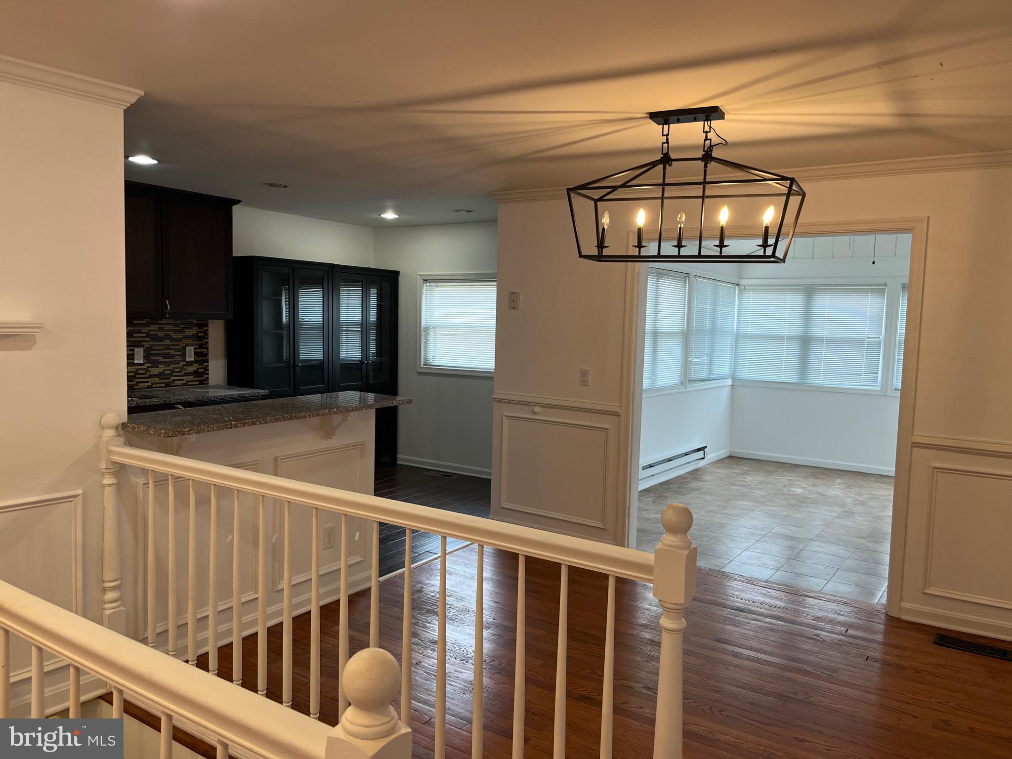 8829 Sigrid Road Randallstown, MD 21133 - Photo 4 of 28 a view of a hallway with wooden floor and chandelier