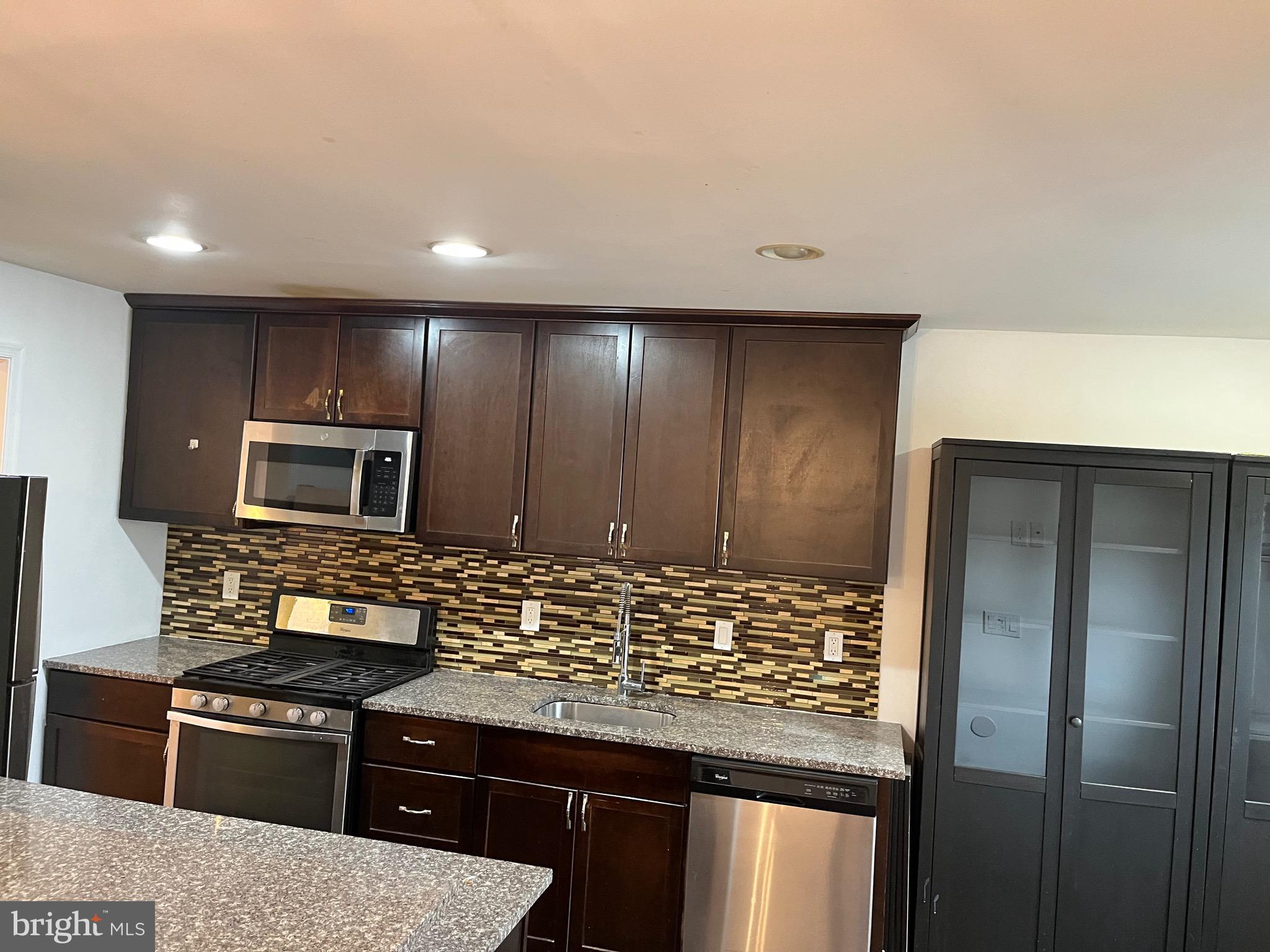 8829 Sigrid Road Randallstown, MD 21133 - Photo 6 of 28 a kitchen with stainless steel appliances kitchen island granite countertop a stove a refrigerator and a microwave