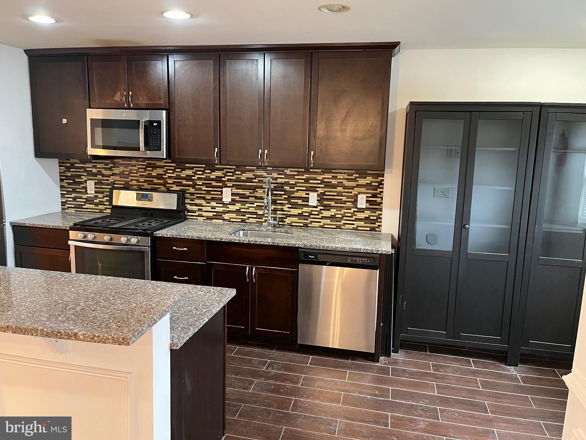 8829 Sigrid Road Randallstown, MD 21133 - Photo 7 of 28 a kitchen with stainless steel appliances granite countertop a stove a sink and a microwave