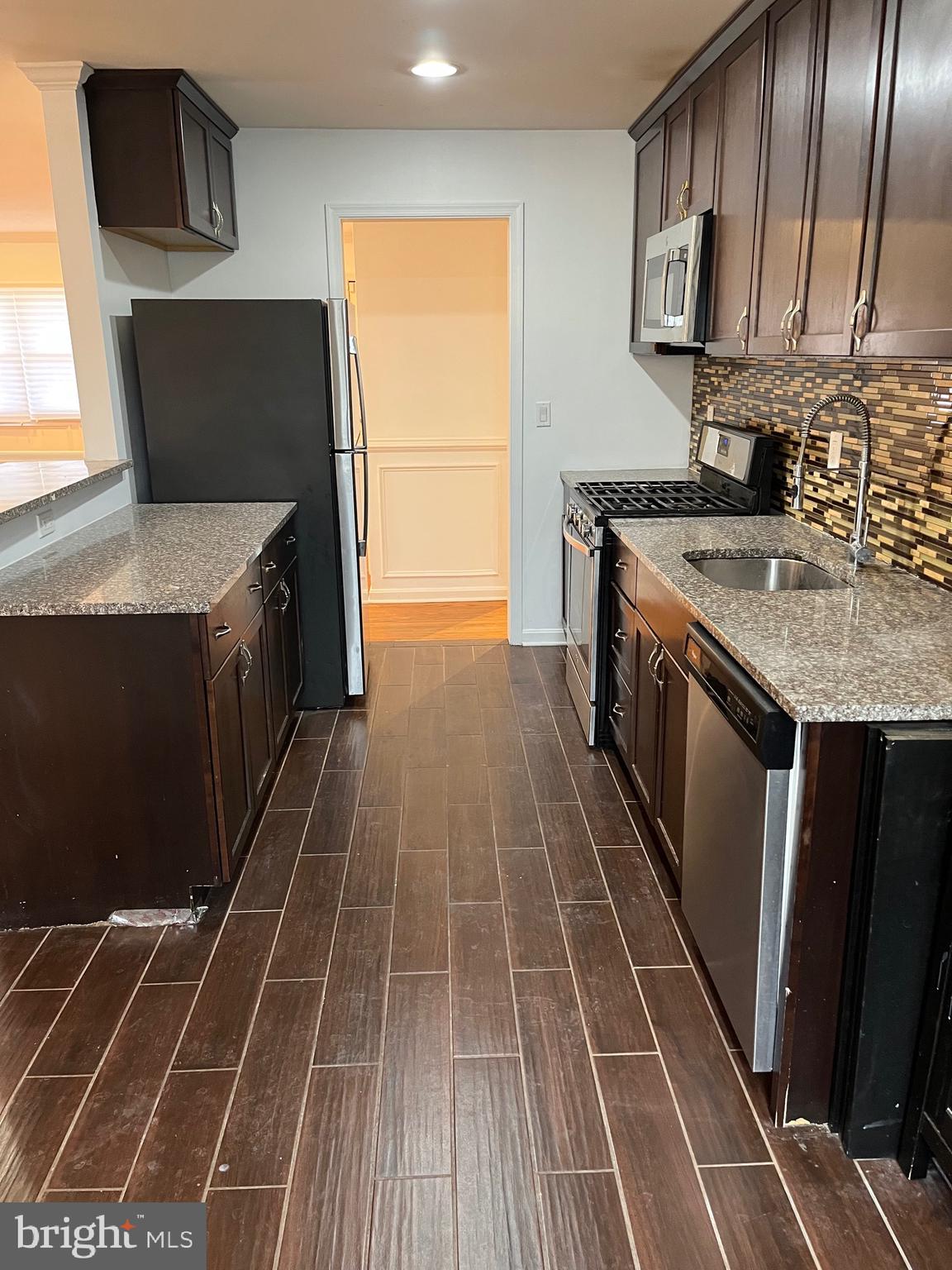 8829 Sigrid Road Randallstown, MD 21133 - Photo 8 of 28 a kitchen with a sink stove and cabinets