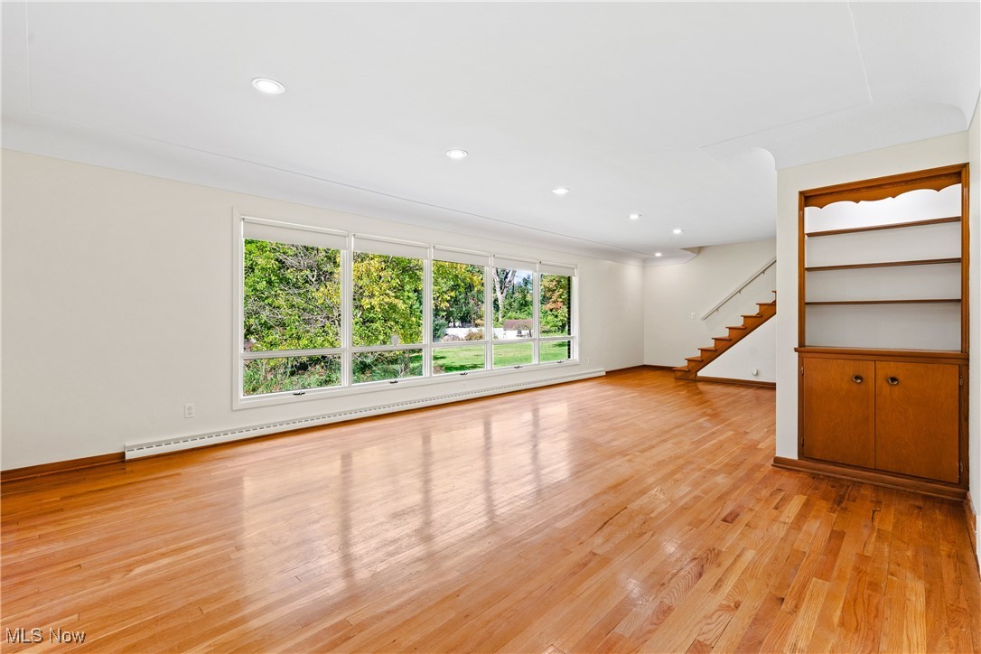 870 Trebisky Road Cleveland, OH 44121 - Photo 5 of 48 Unfurnished living room featuring a baseboard heating unit and light hardwood / wood-style flooring
