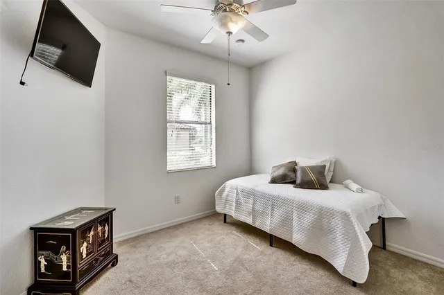 a bedroom with a bed a flat screen tv and a chandelier