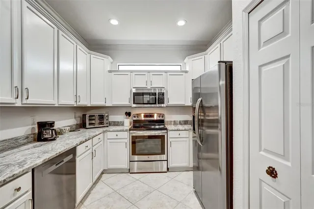 a kitchen with stainless steel appliances granite countertop a refrigerator stove and sink