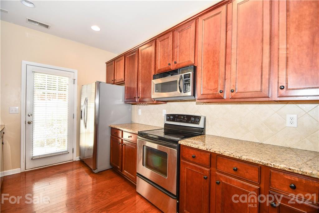 1903 Travertine Lane Fort Mill, SC 29708 - Photo 6 of 20 a kitchen with stainless steel appliances granite countertop a stove a microwave and a refrigerator