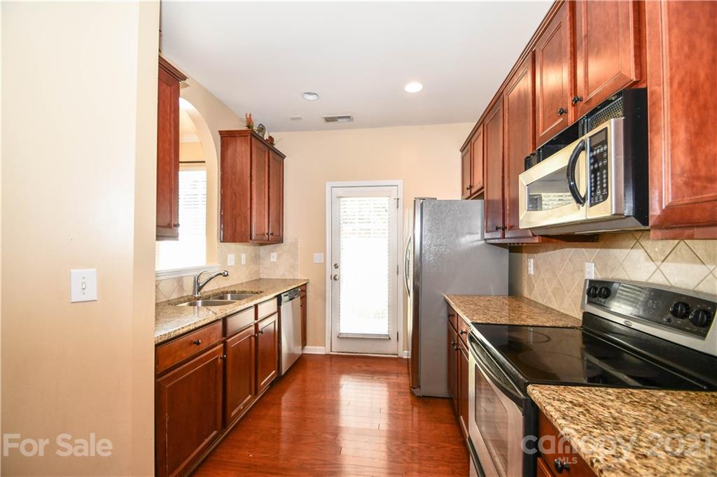 1903 Travertine Lane Fort Mill, SC 29708 - Photo 7 of 20 a kitchen with stainless steel appliances granite countertop a refrigerator a stove and a sink with wooden floor