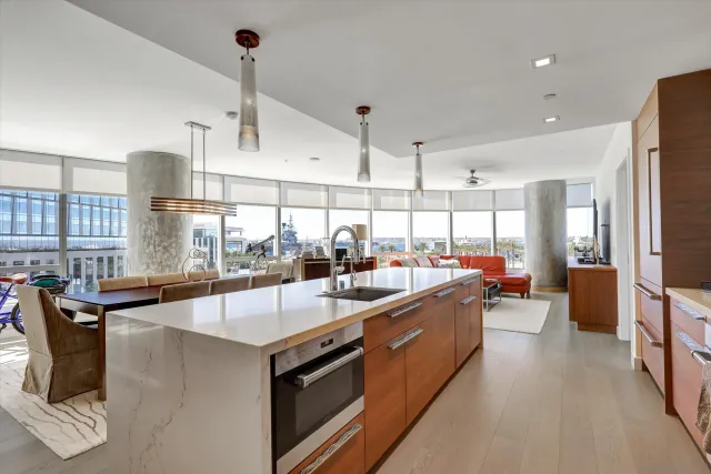 a large kitchen with kitchen island a large counter top space a sink stainless steel appliances and windows