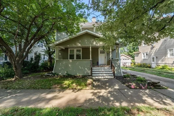 a view of a house with a yard and large tree