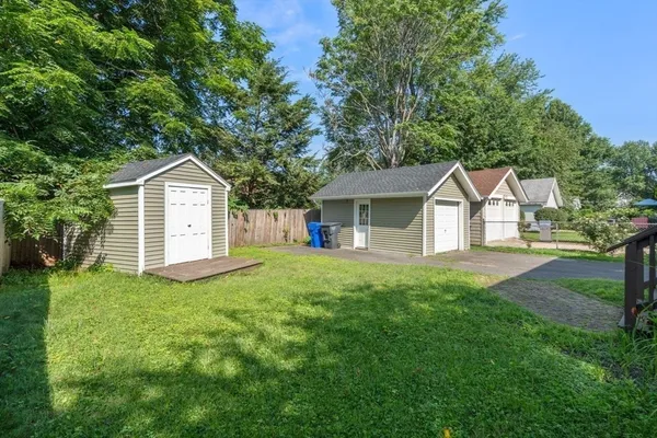 a front view of a house with a yard and trees
