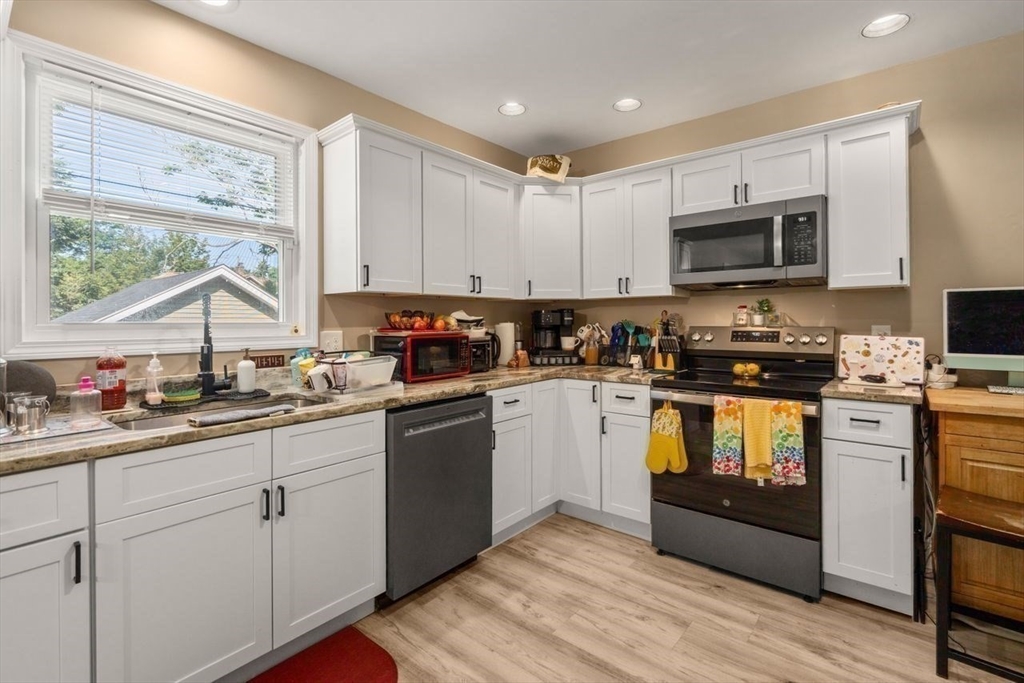 38 Manchester Terrace Springfield, MA 01108 - Photo 7 of 15 a kitchen with granite countertop white cabinets sink and stainless steel appliances
