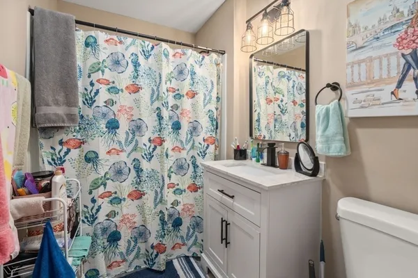 a bathroom with a sink toilet and shower curtain