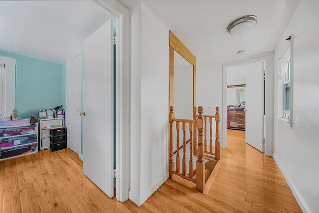 a view of a hallway with wooden floor and furniture