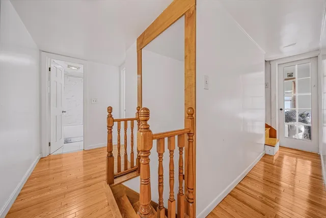 a view of a hallway with wooden floor and staircase