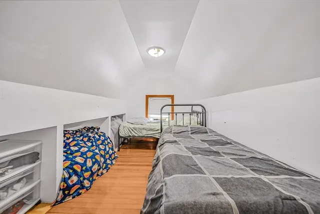 a bedroom with a bed and a lamp on dresser