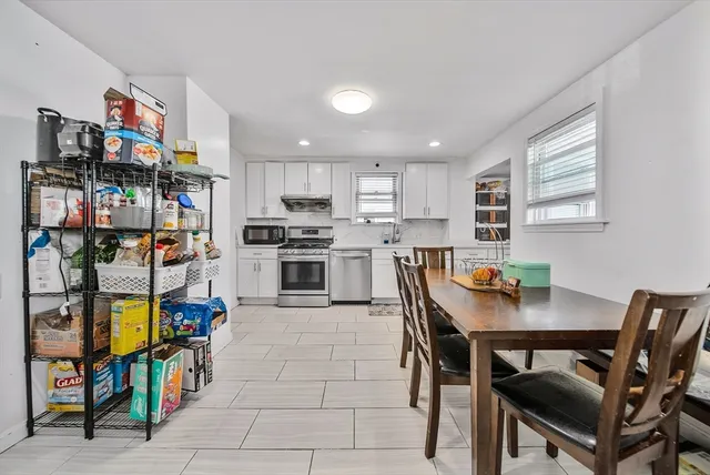 a kitchen with stainless steel appliances kitchen island granite countertop a table chairs microwave and sink