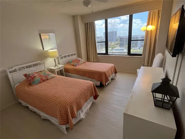 a bedroom with two beds and large window