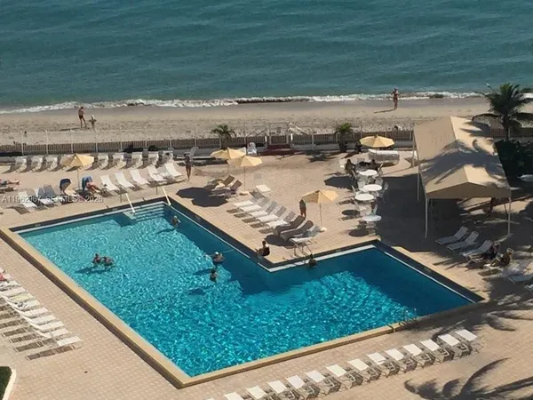 a view of a pool with lawn chairs