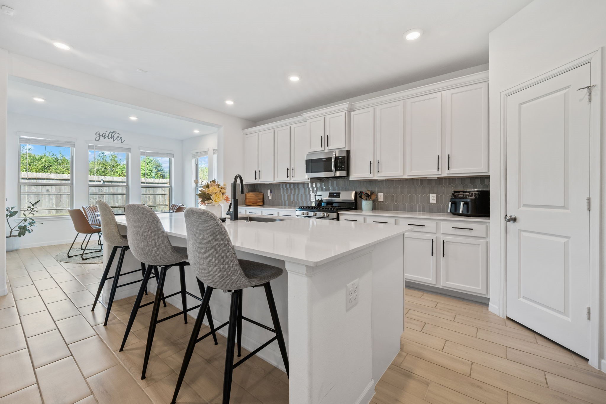 4218 Redford Valley Road Rosharon, TX 77583 - Photo 8 of 36 a kitchen with stainless steel appliances kitchen island granite countertop a stove a sink a refrigerator with white cabinets and couches