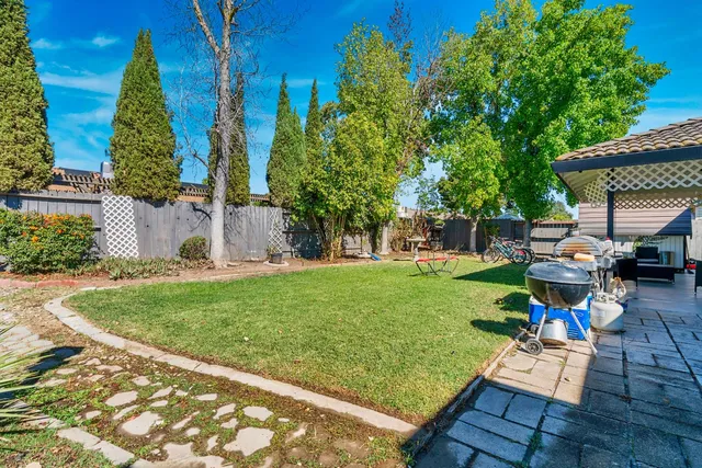 a view of backyard with seating area and trees