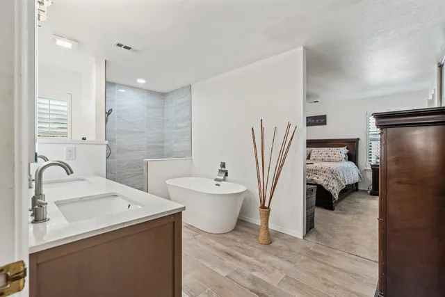 a bathroom with a sink and mirror with bathtub