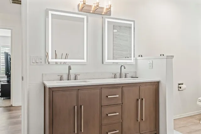a bathroom with a granite countertop sink vanity and mirror