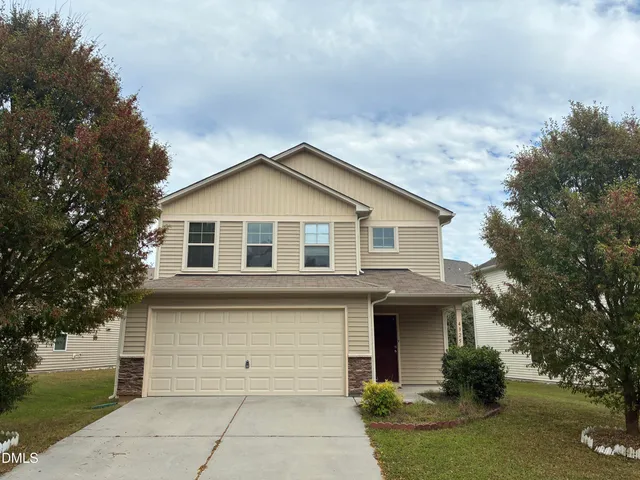 a front view of a house with a garden