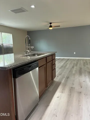 a view of an empty room with wooden floor and window