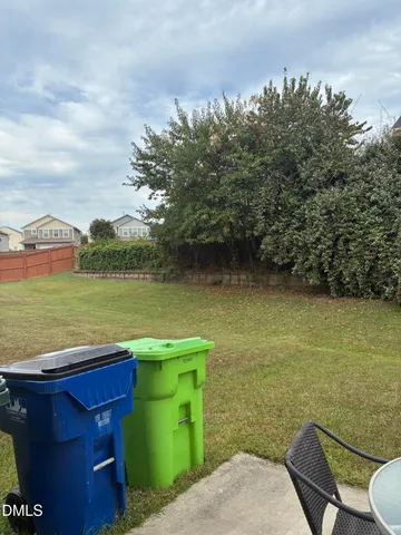 a view of backyard of house with outdoor seating and green space