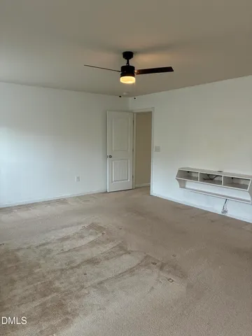 an empty room with a window and a ceiling fan