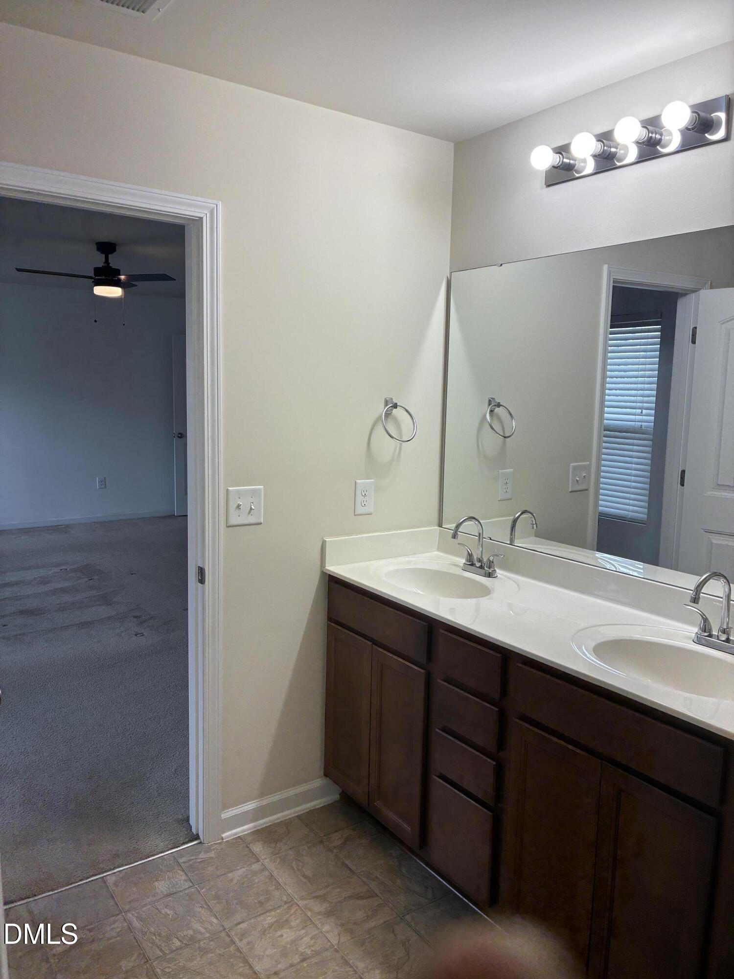 4325 Lyman Avenue Raleigh, NC 27616 - Photo 36 of 52 a bathroom with a double vanity sink and a mirror