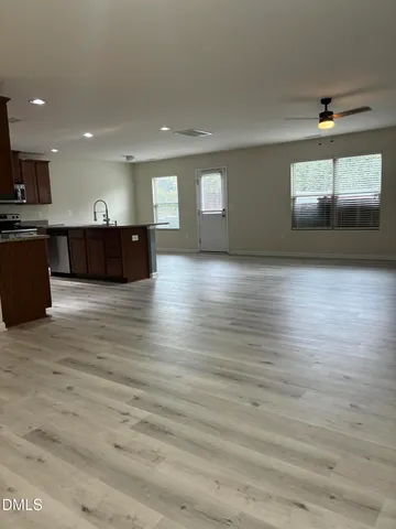 a large kitchen with stainless steel appliances kitchen island granite countertop a large counter top and wooden floors