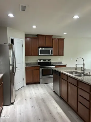a metallic refrigerator freezer sitting inside of a kitchen