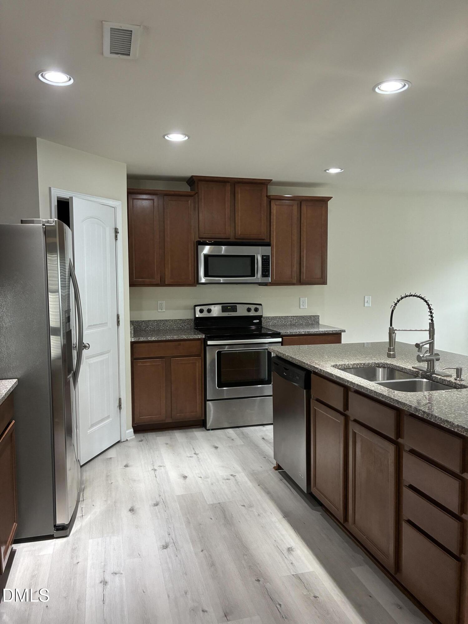 4325 Lyman Avenue Raleigh, NC 27616 - Photo 9 of 52 a kitchen with stainless steel appliances granite countertop a stove a sink and a refrigerator