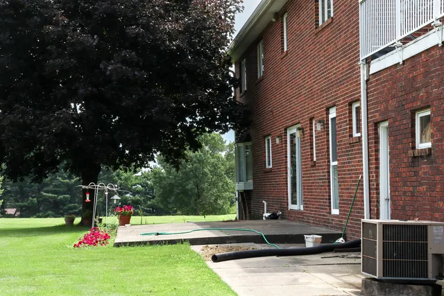 a view of a house with backyard and sitting area