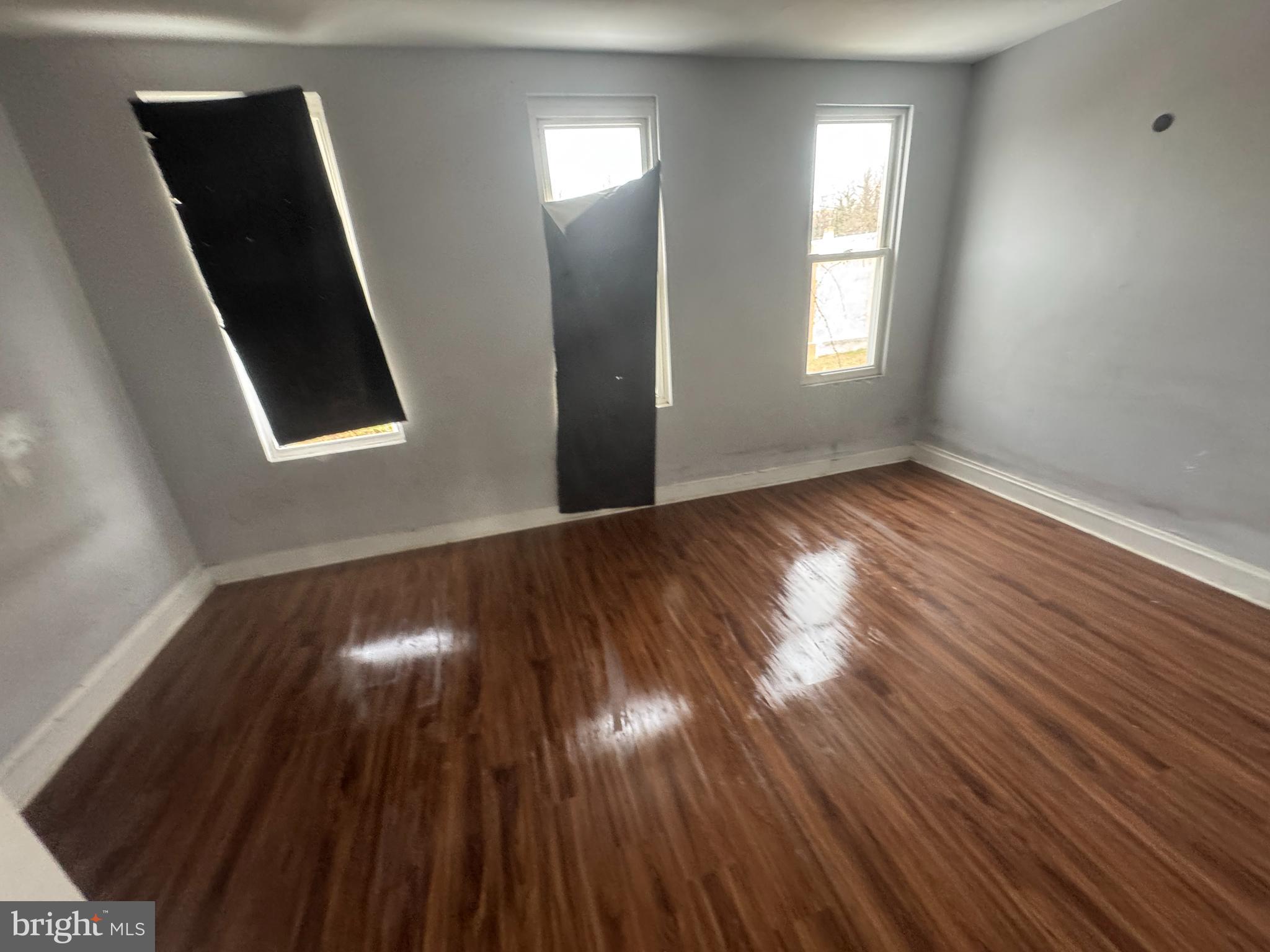 2801 Presbury Street Baltimore, MD 21216 - Photo 14 of 17 an empty room with wooden floor and windows