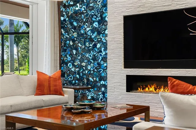 a living room with a fireplace a flat screen tv and a large window