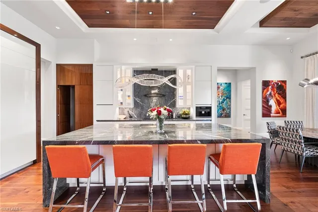 a dining table with chairs and kitchen view