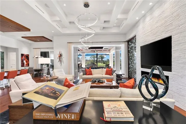 a living room with furniture a flat screen tv and a large window