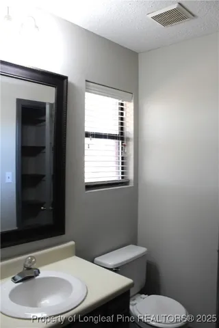 a bathroom with a toilet a sink and mirror