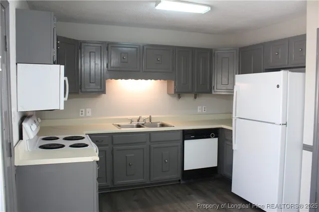 a view of a kitchen with sink and refrigerator