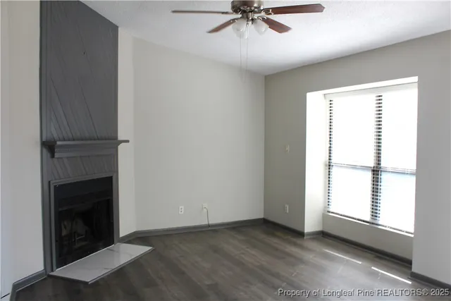 a view of an empty room with a fireplace and a window