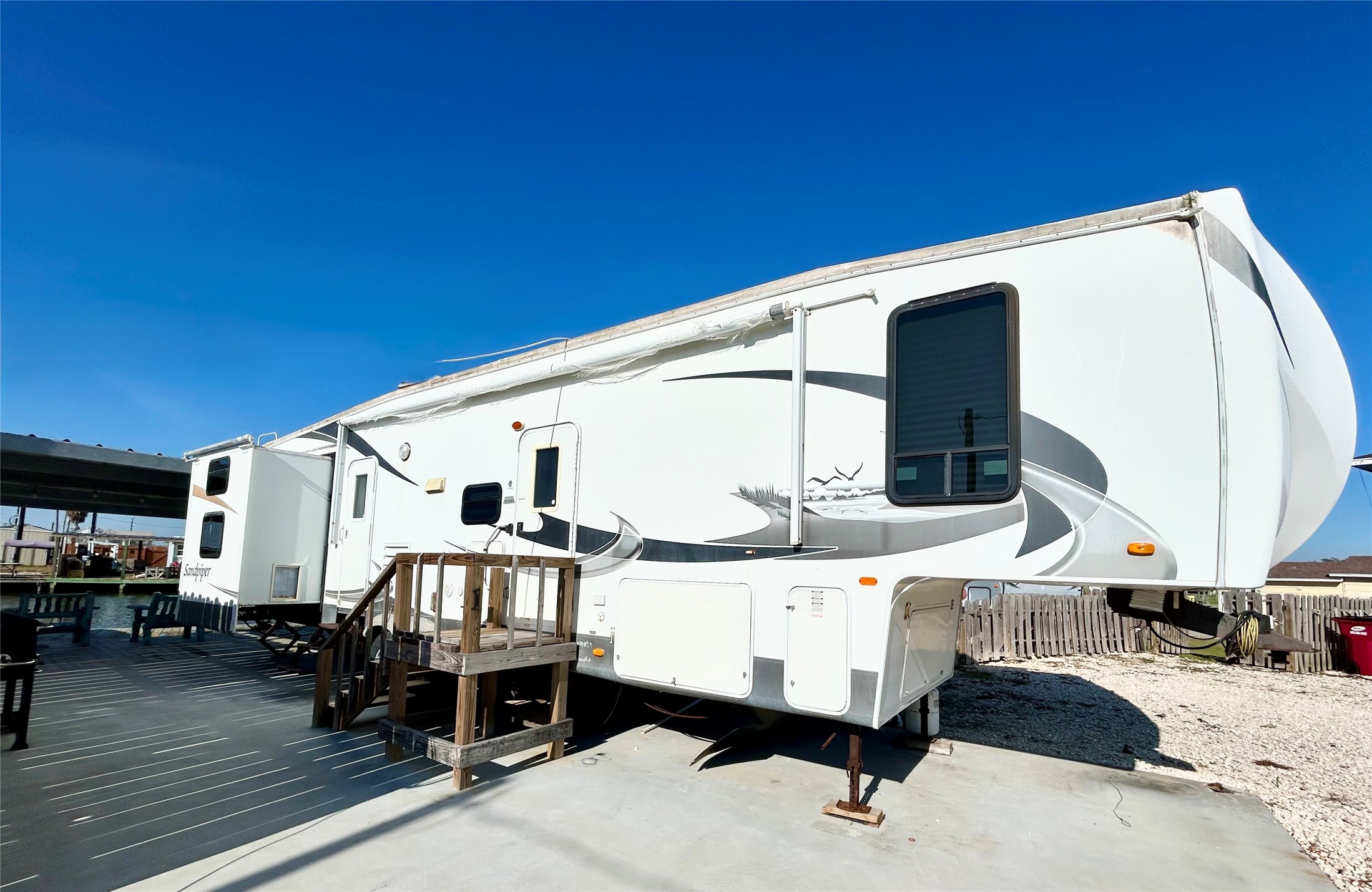 151 Neptune Sargent, TX 77414 - Photo 16 of 26 a view of a balcony with chairs and couches with wooden floor and fence