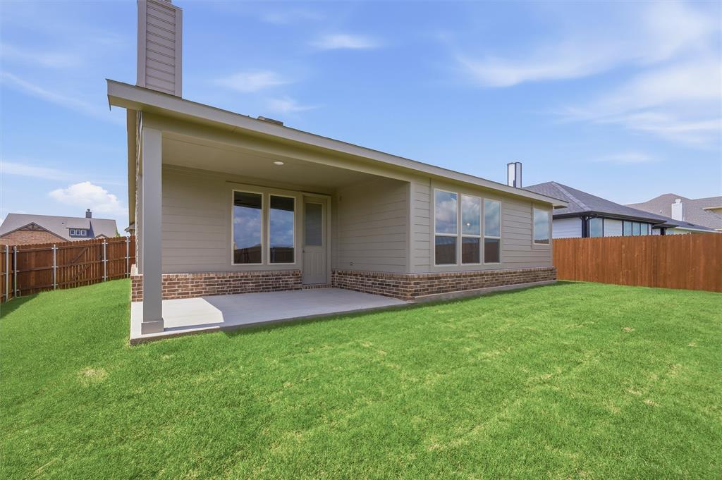 1217 Colca Drive Springtown, TX 76082 - Photo 22 of 25 Expansive backyard featuring a covered patio with concrete flooring, siding exterior with brick accents, and a privacy fence
