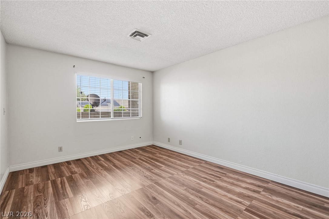 3971 Spring Leaf Drive Las Vegas, NV 89147 - Photo 16 of 48 Neutral walls and rich wood-toned flooring create a versatile blank canvas for any lifestyle.