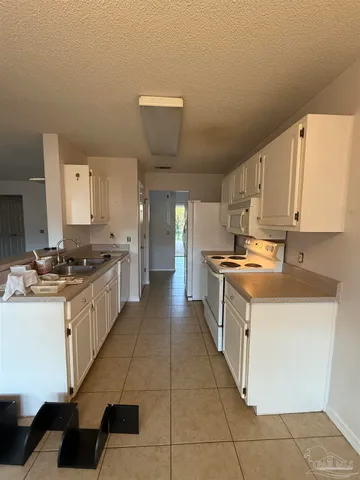 a large kitchen with stainless steel appliances a sink and cabinets