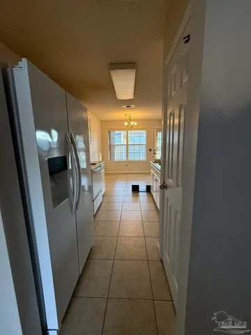 a hallway with windows and a refrigerator