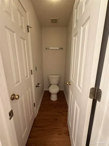a bathroom with a toilet and a view of a bathroom