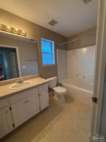 a spacious bathroom with a double vanity sink a toilet and shower